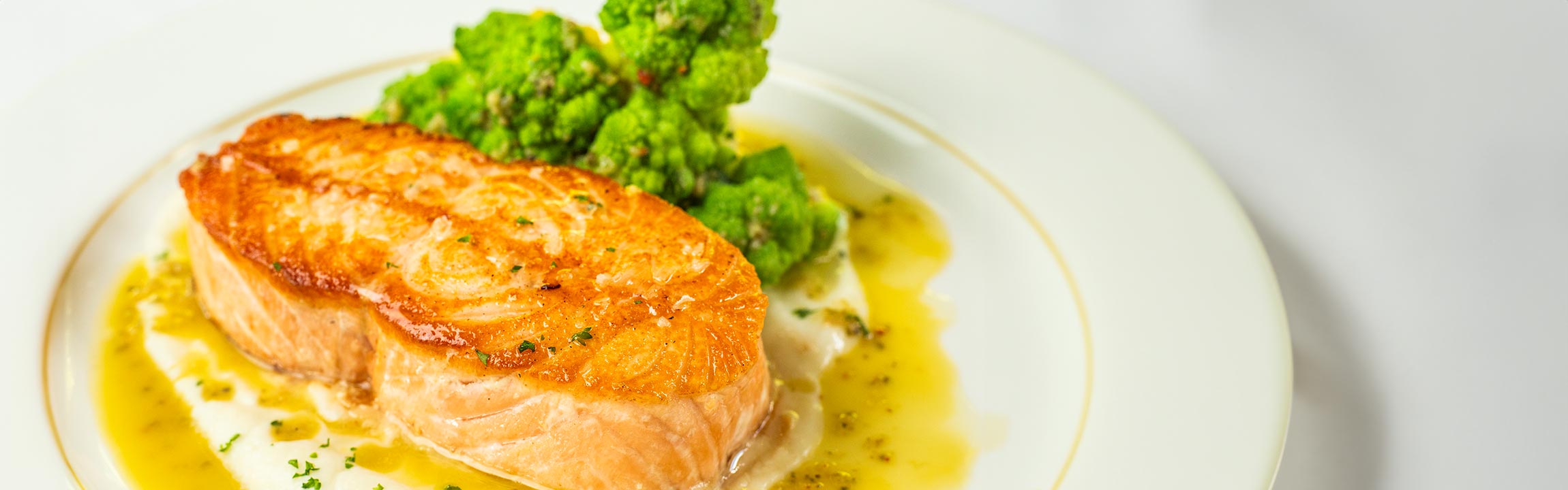 Salmon Steak on puréed cauliflower with romanescu and caper vinaigrette served at Butcher & Rose in Columbus, Ohio.